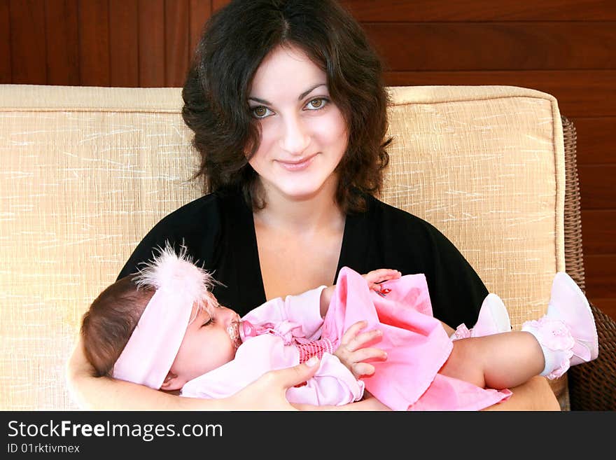 Pretty brunette girl with sleeping baby. Pretty brunette girl with sleeping baby.