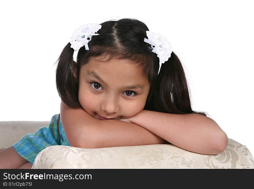 Pretty girl in blue dress resting on arm of couch. Pretty girl in blue dress resting on arm of couch