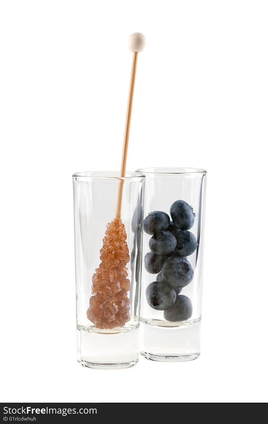 Rock sugar and huckleberries in glass, isolated on white background