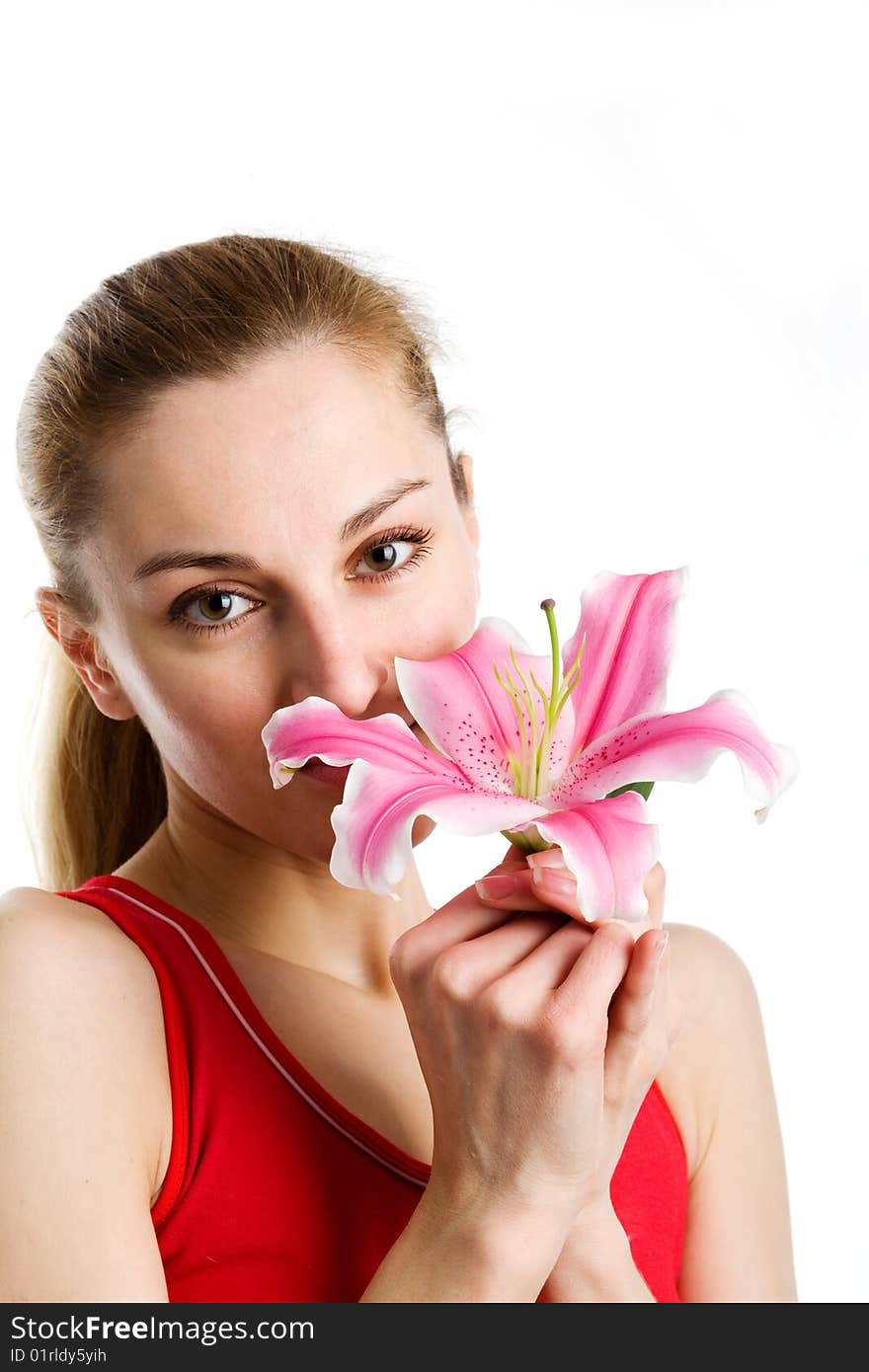 A portrait of a nice blond girl in red with a pink lily near her face on a white background. A portrait of a nice blond girl in red with a pink lily near her face on a white background