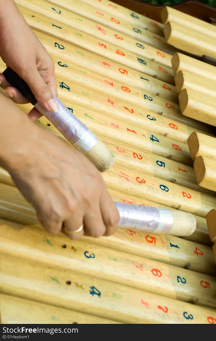 Woman's hands playing kolintang. Kolintang is wooden xylophone, a traditional musical instrument from northern Sulawesi, Indonesia, South East Asia. Woman's hands playing kolintang. Kolintang is wooden xylophone, a traditional musical instrument from northern Sulawesi, Indonesia, South East Asia