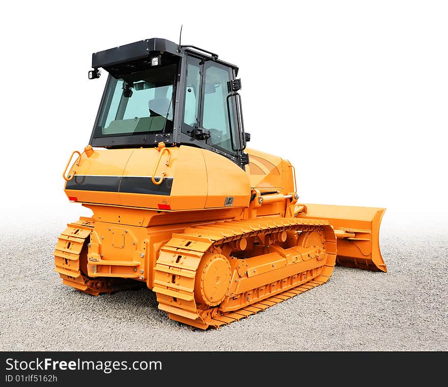 Yellow bulldozer over a grey gravel