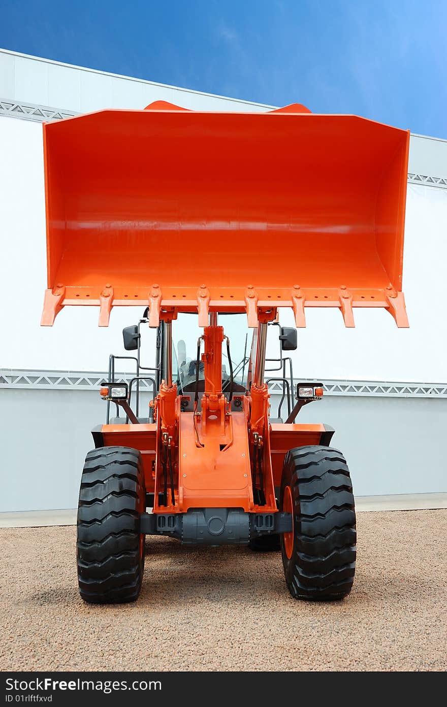 Orange bulldozer over a brown gravel