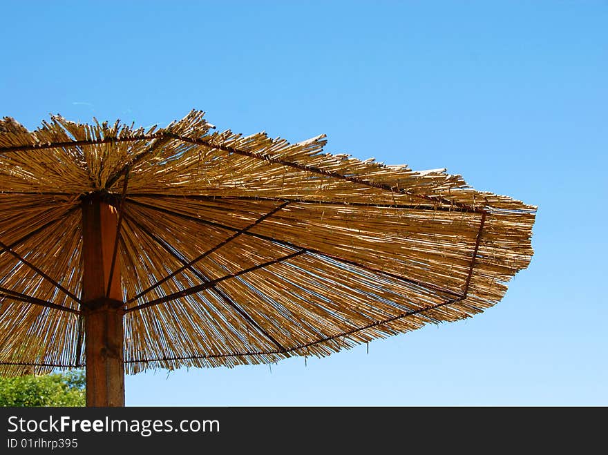 Straw umbrella details over blue sky outdoor