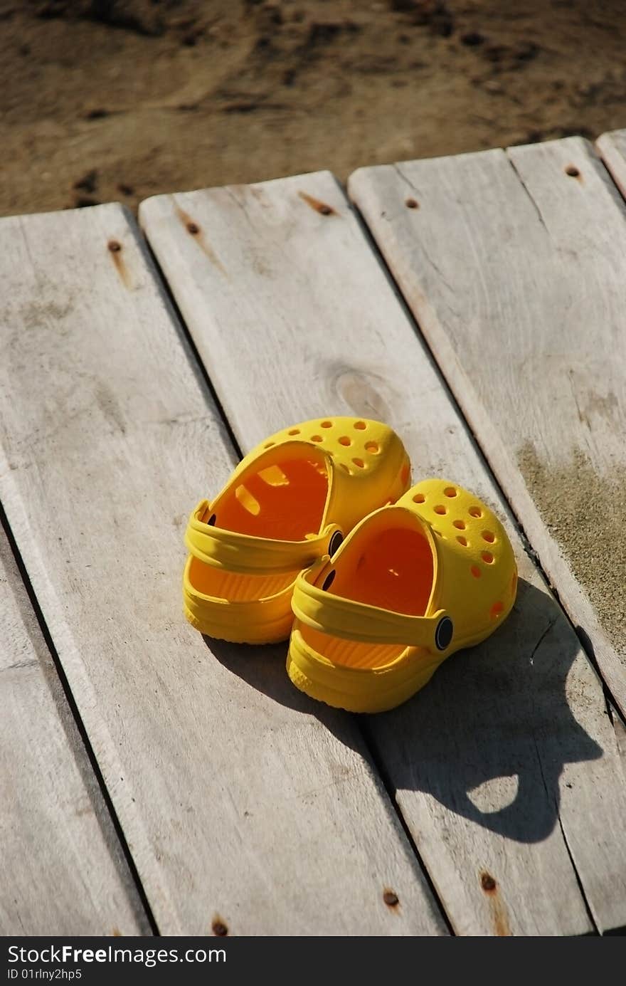 Kid sandals on wooden plate