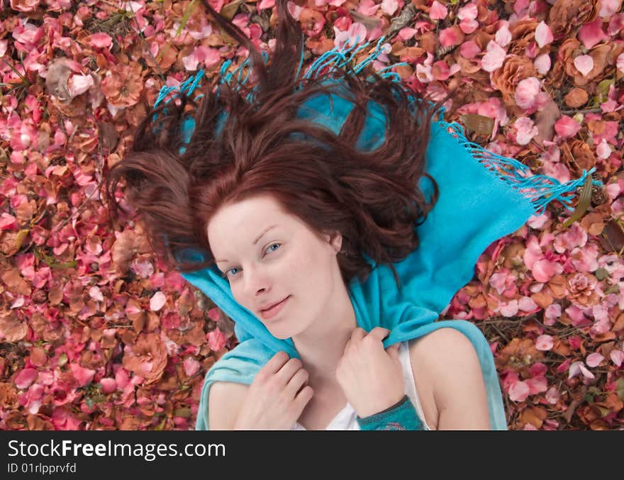 Young woman laying on ground covered with petals