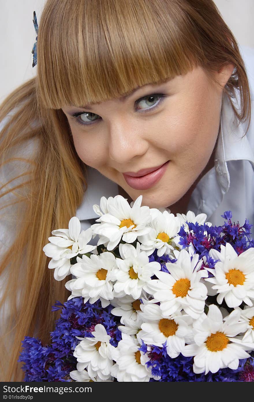 The beautiful woman in a blue shirt with flowers. The beautiful woman in a blue shirt with flowers