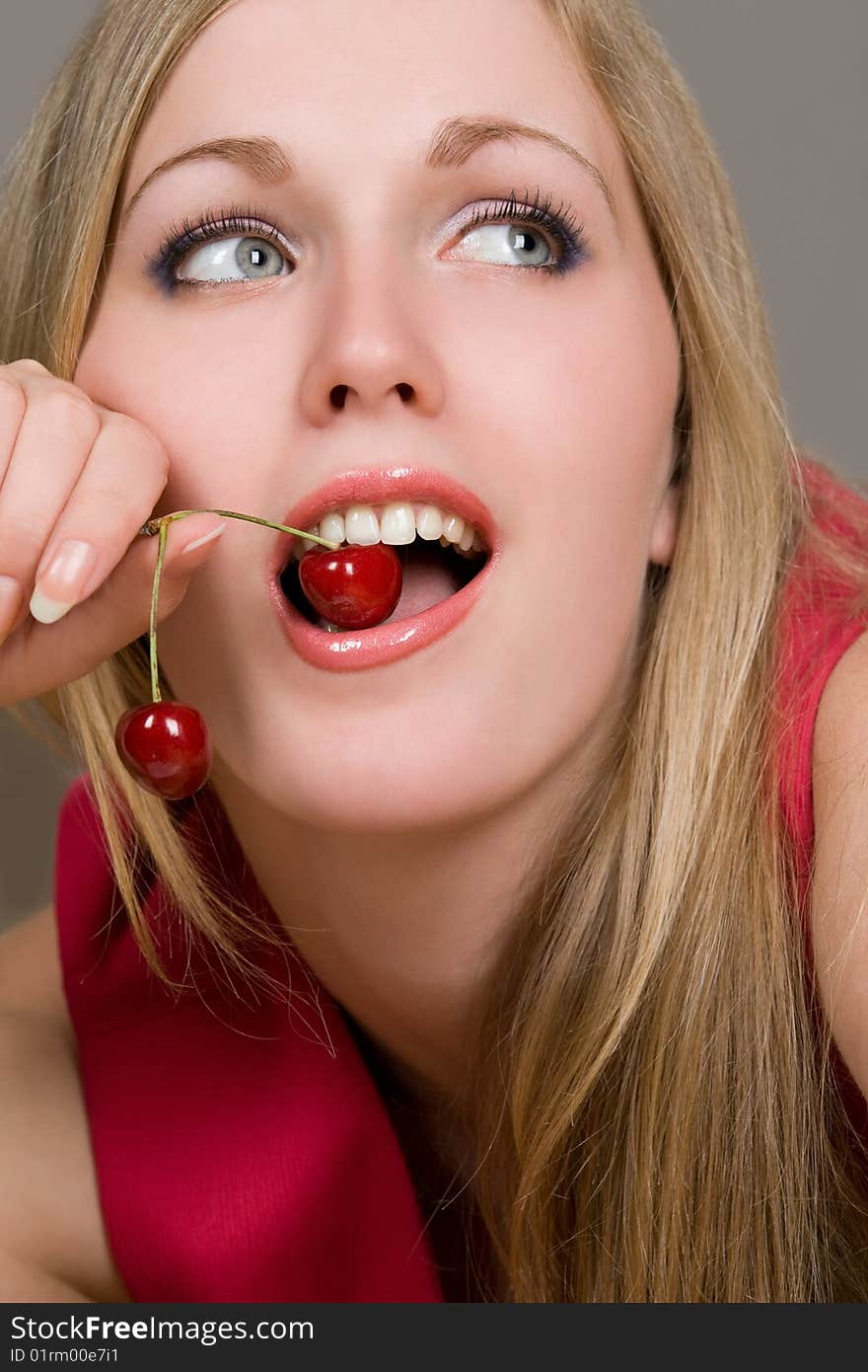 Healthy young woman eating red cherries