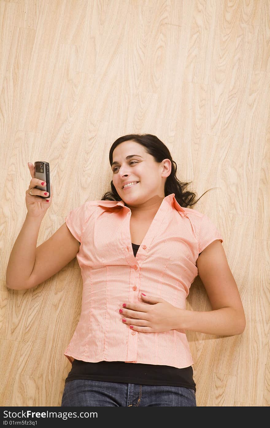 Overhead shot of woman lying on back using mobile device. Overhead shot of woman lying on back using mobile device