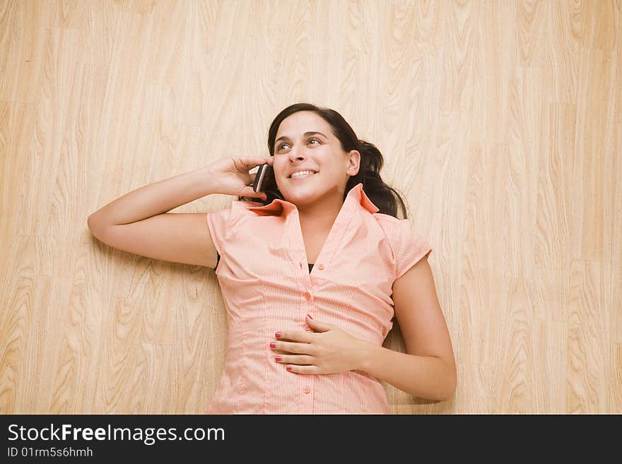 Overhead shot of woman lying on back using mobile device. Overhead shot of woman lying on back using mobile device