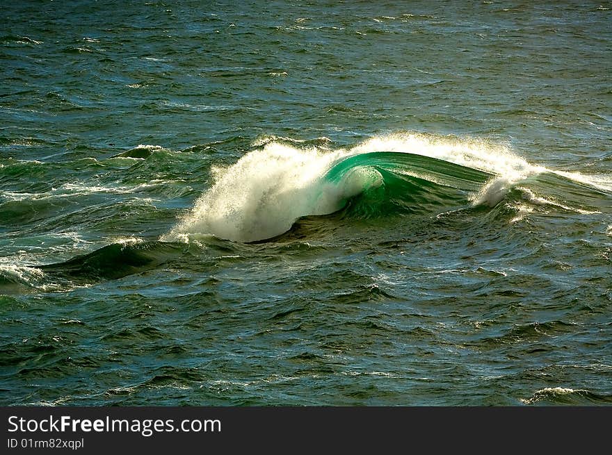 Single wave breaking offshore surrounded by open water