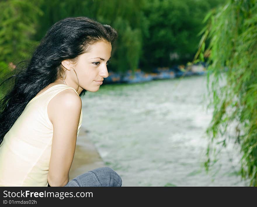 Pretty girl sitting by the lake. Pretty girl sitting by the lake