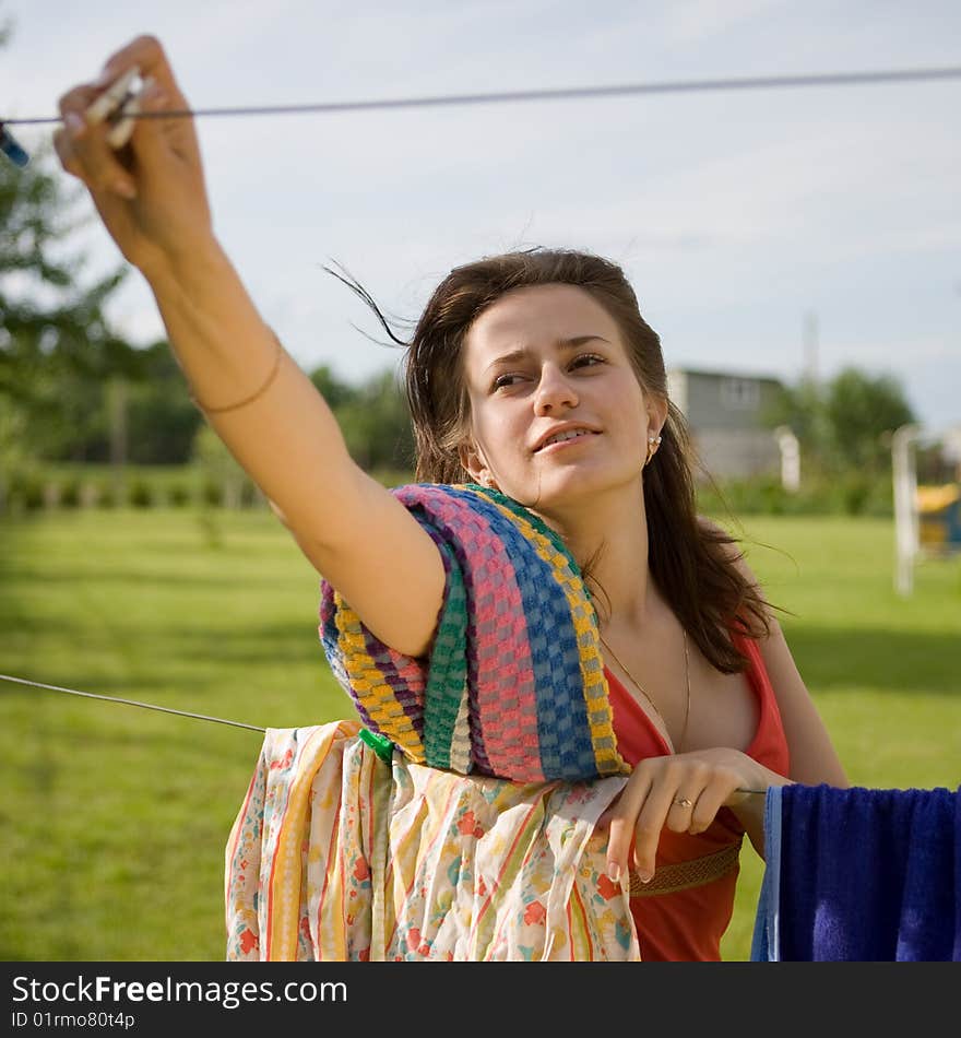 Young women (housewife) hang washing on the line