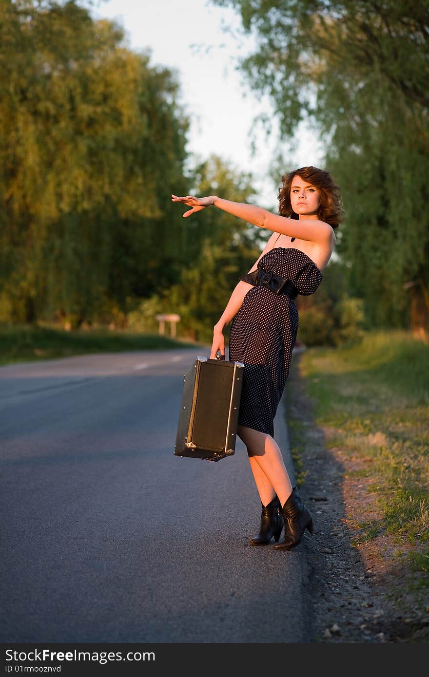 Young woman waitin a car from the roadside