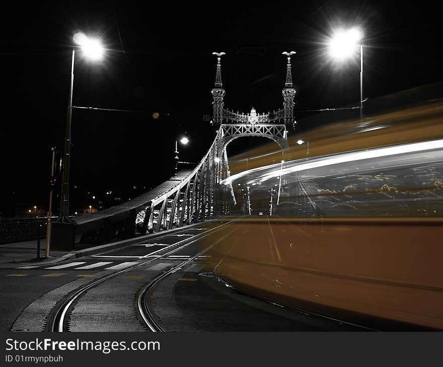 Tram turning on to a bridge at night