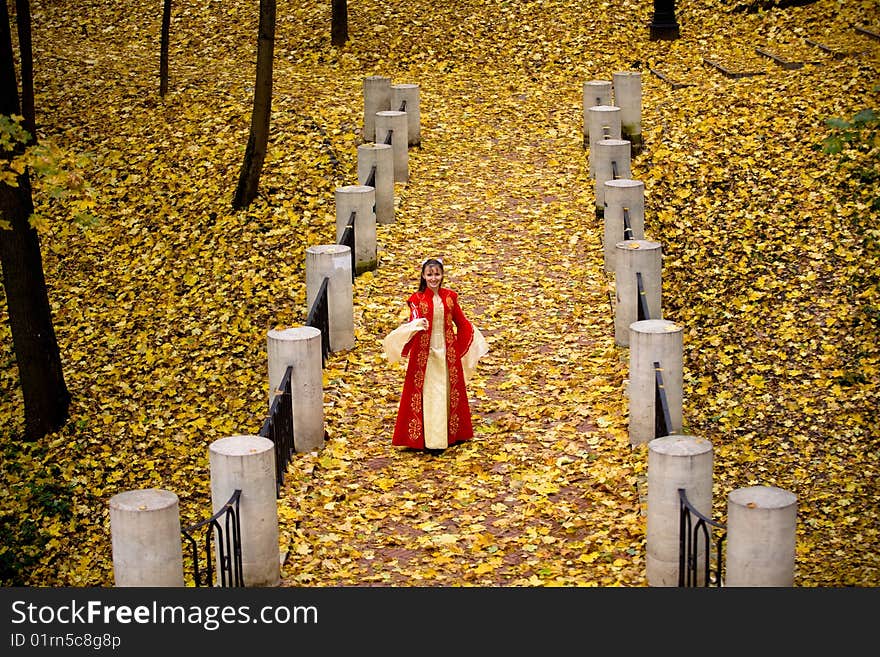 Lady in medieval red dress in the autumn forest. Lady in medieval red dress in the autumn forest