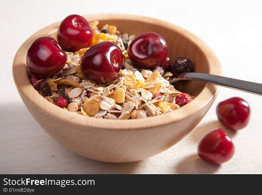 Muesli with cherry in wooden bowl