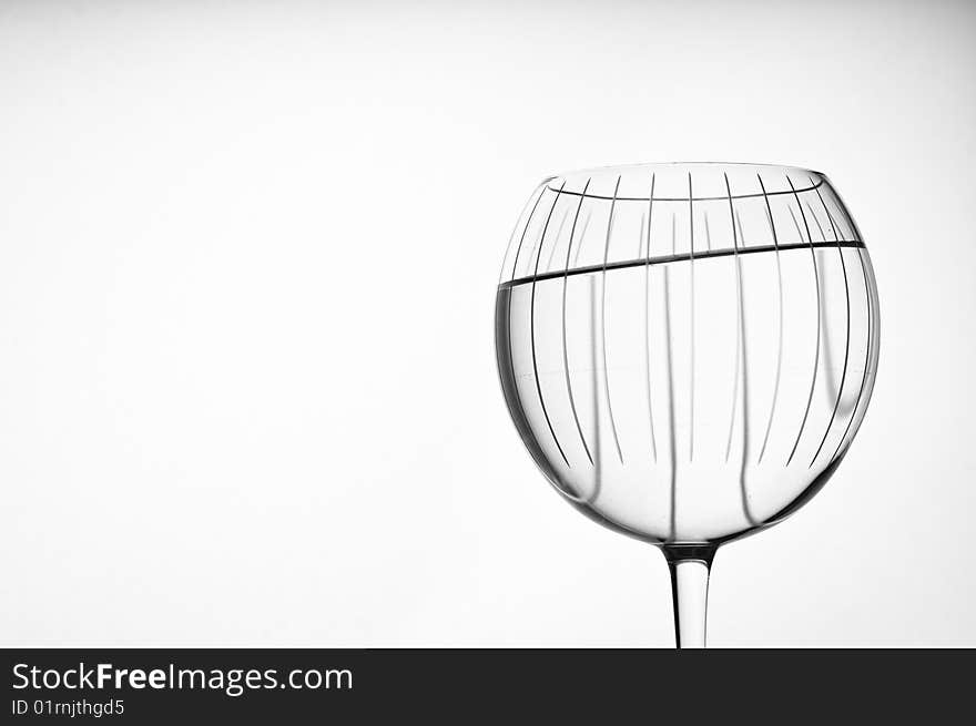 Large red wine crystal bowl glass isolated on white with water tipping