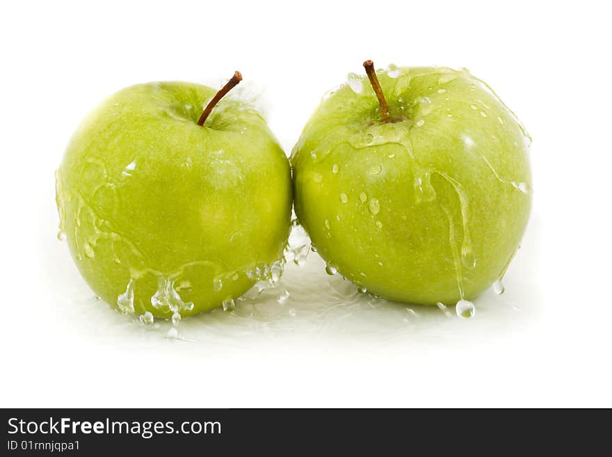 Two green apples with droplets on a white background