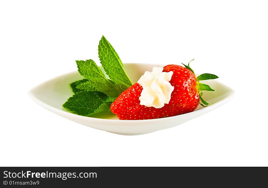 Ripe strawberry with cream on a white plate