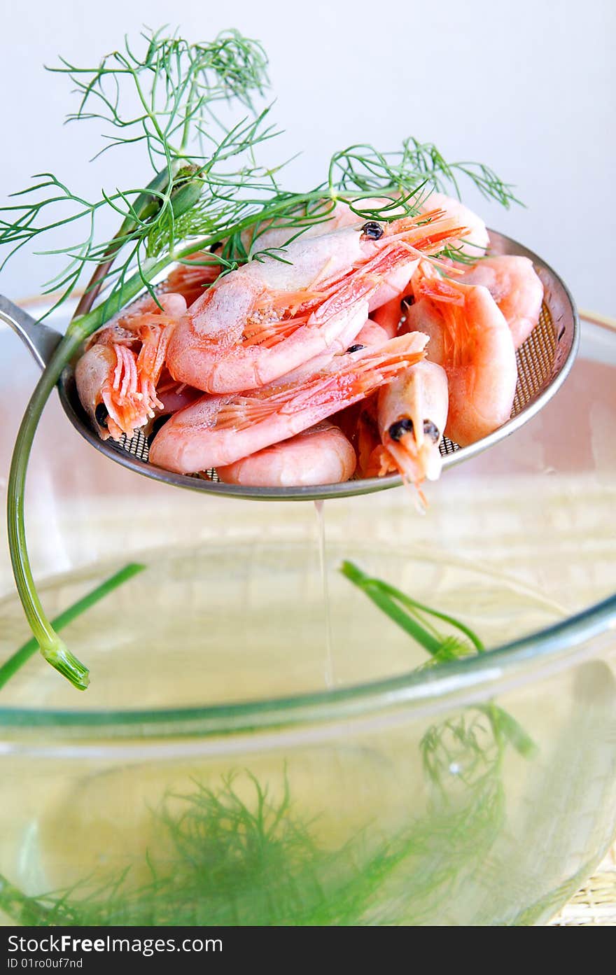 Boiled little shrimps with dill sprig on a skimmer, closeup, blur background. Boiled little shrimps with dill sprig on a skimmer, closeup, blur background