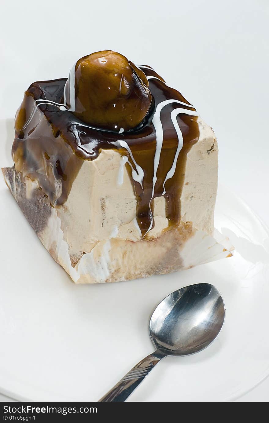 Profiterole covered with chocolate syrup on white plate