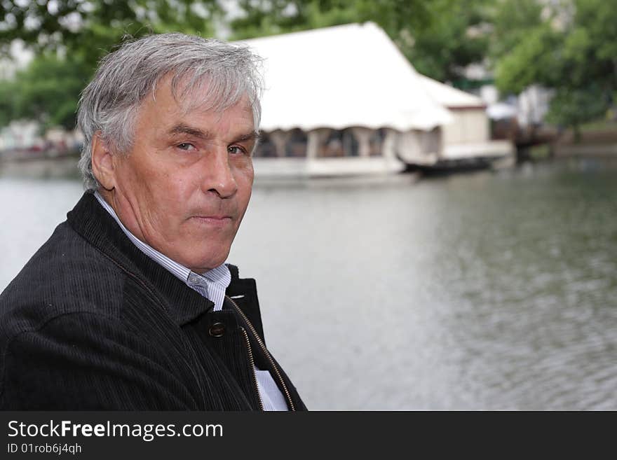 The man poses on a pond background. The man poses on a pond background