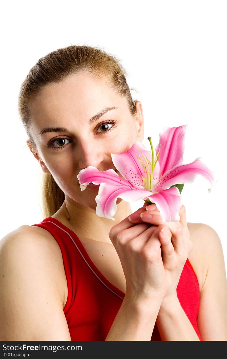 A portrait of a nice blond girl in red with a pink lily near her face on a white background. A portrait of a nice blond girl in red with a pink lily near her face on a white background