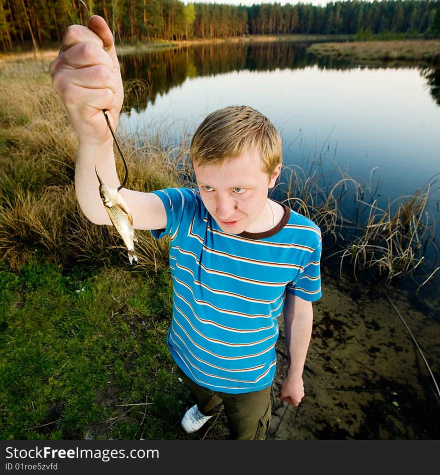 A cute guy showing a fish. A cute guy showing a fish