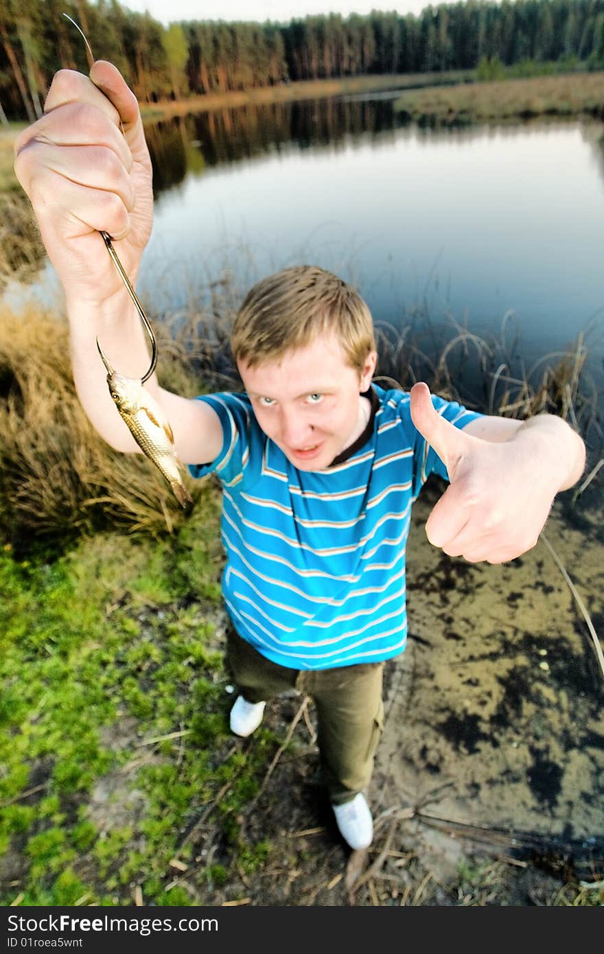 A cute guy showing a fish. A cute guy showing a fish