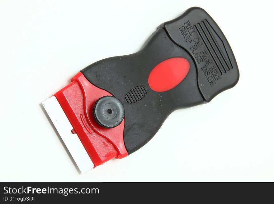 Red and black box cutter with blade.