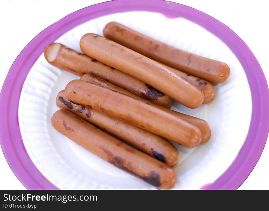 Grilled hot dogs on paper plate isolated on white background