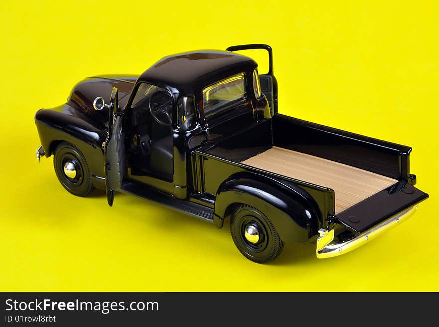 A vintage truck model, isolated on yellow in a studio.