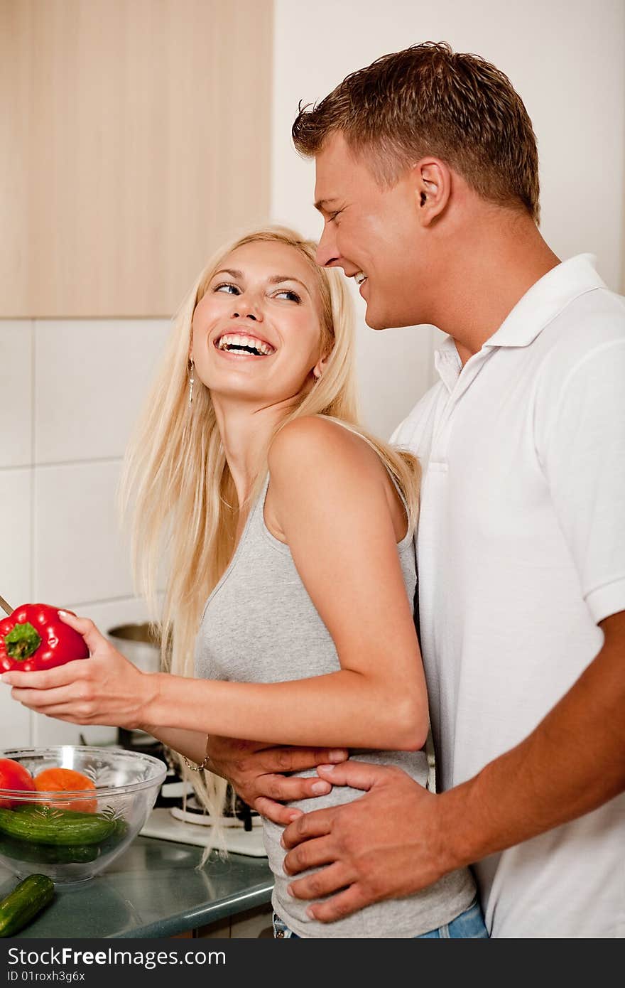 Happy couple preparing food in the kitchen