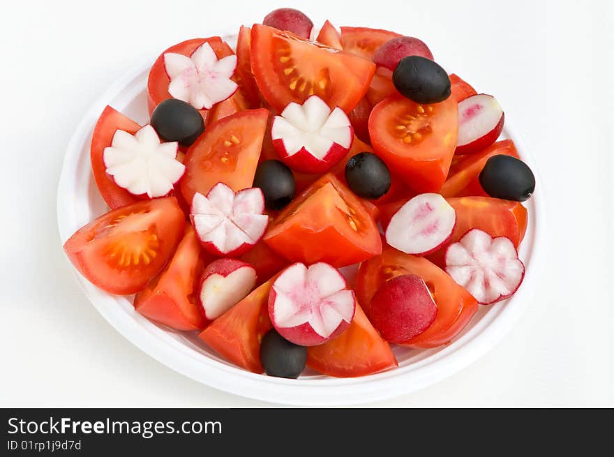 Tomato radish and olives skilfully cut on a white background. Tomato radish and olives skilfully cut on a white background