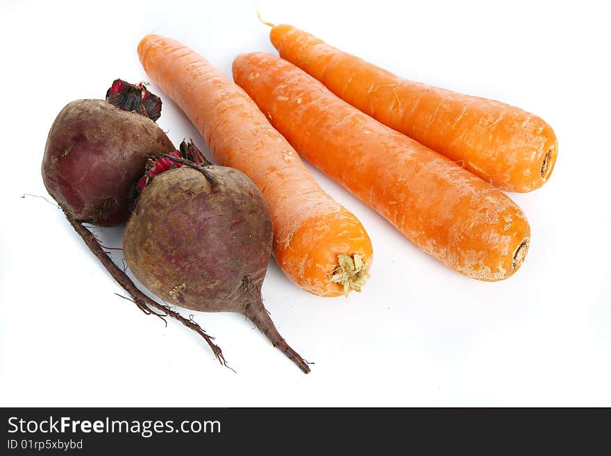 Three big  fresh carrots and two  beets on the  table. Three big  fresh carrots and two  beets on the  table