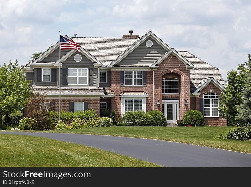 Luxury brick home in suburbs with American flag