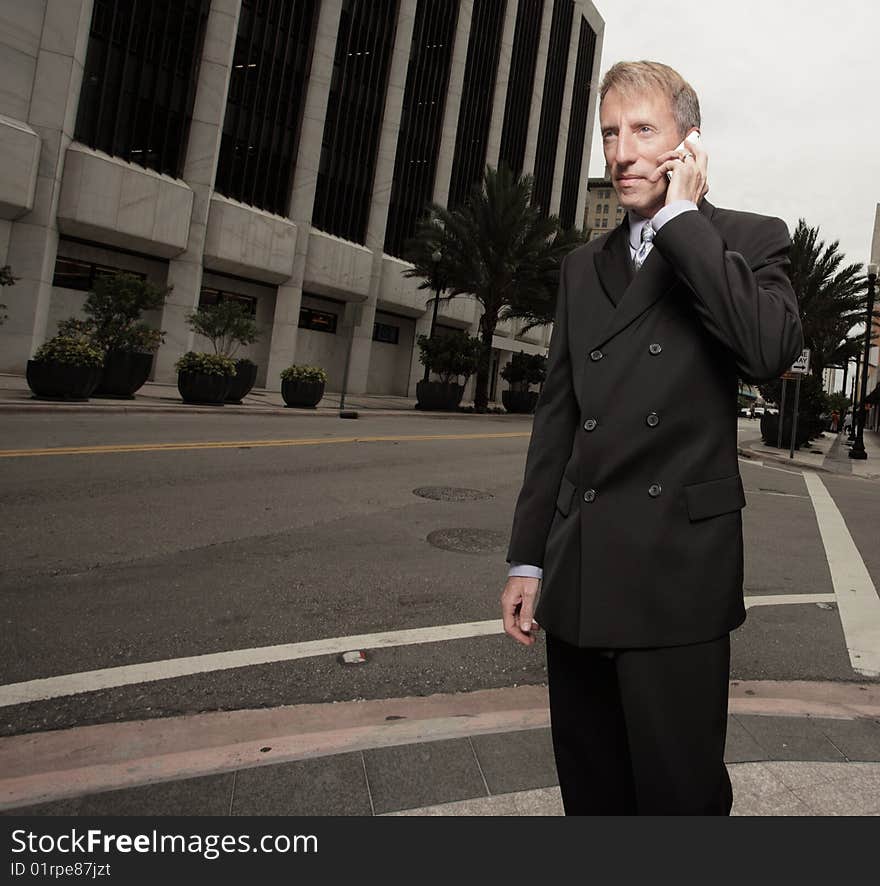 Businessman in the city talking on a cellphone. Businessman in the city talking on a cellphone