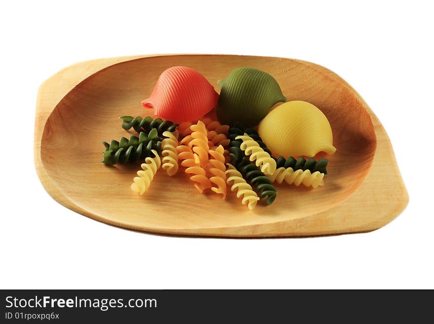 Coloured pasta on wooden plate