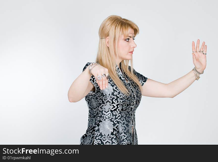 Blond woman in black and silver kimono exercising, studio shot. Blond woman in black and silver kimono exercising, studio shot