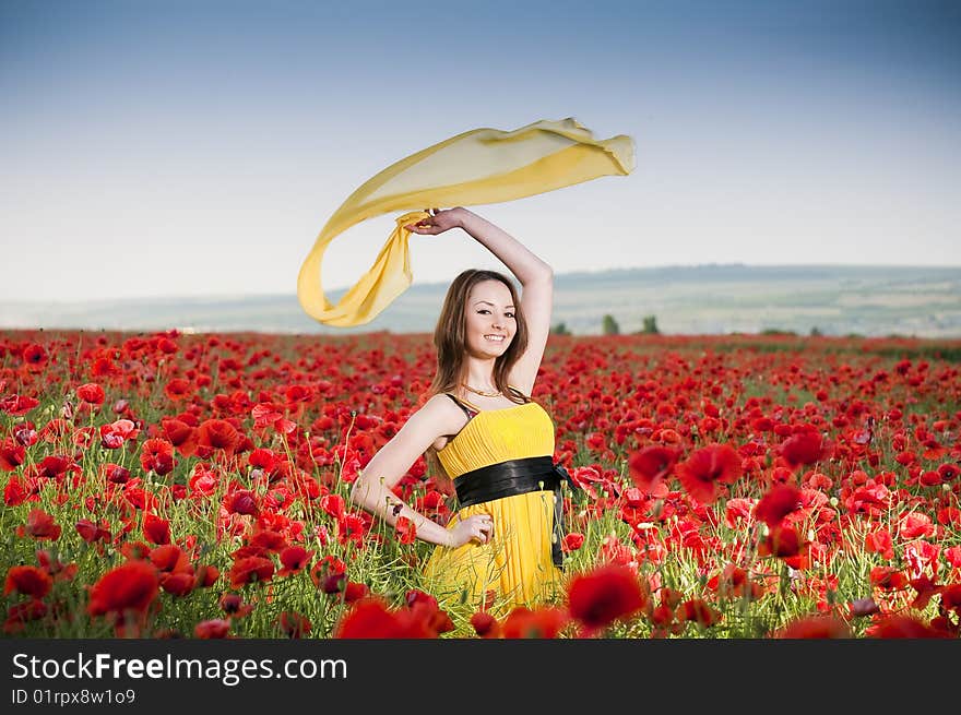 Attractive girl in yellow dress in the poppy field. Attractive girl in yellow dress in the poppy field