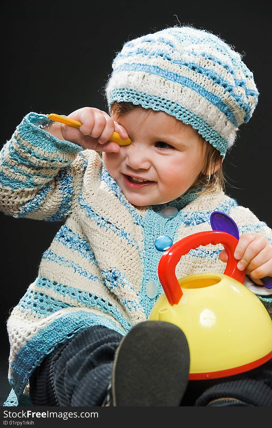 Little girl in bound suit with toys on black background. Little girl in bound suit with toys on black background