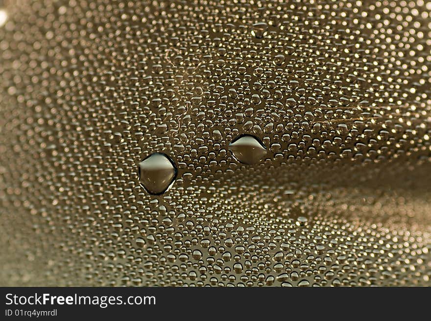 Closeup abstract of many condensated drops of water on a transparent surface. Closeup abstract of many condensated drops of water on a transparent surface.