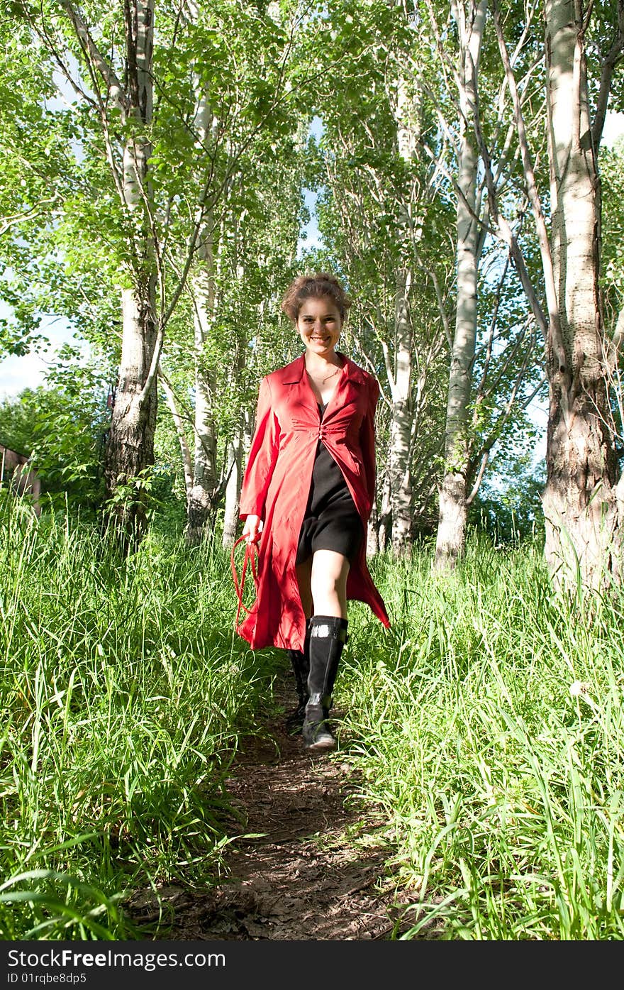 Young girl in red cloack, walking in the park