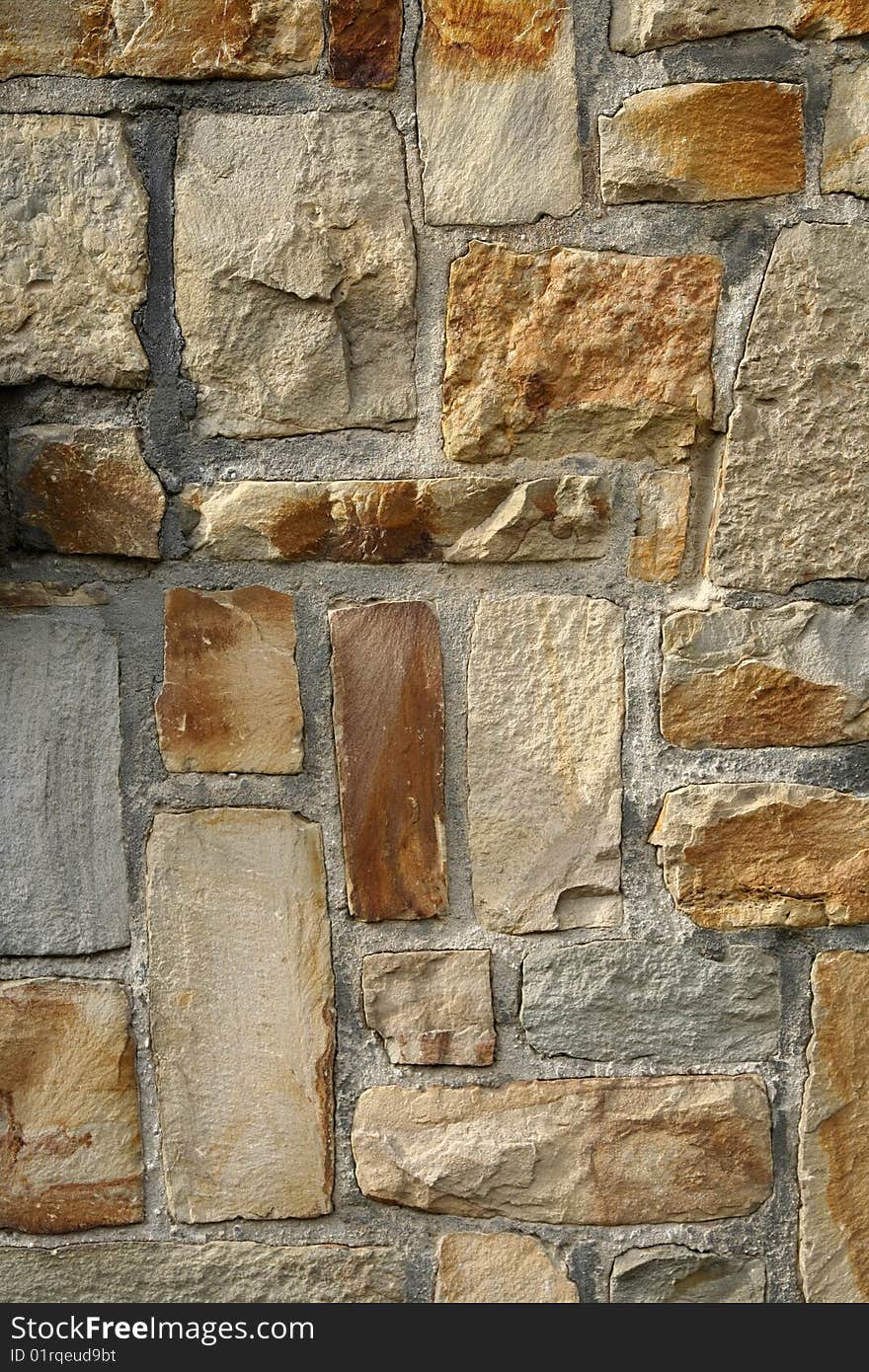 Photo texture of a stone brick wall with bricks in various nuances of beige. Photo texture of a stone brick wall with bricks in various nuances of beige