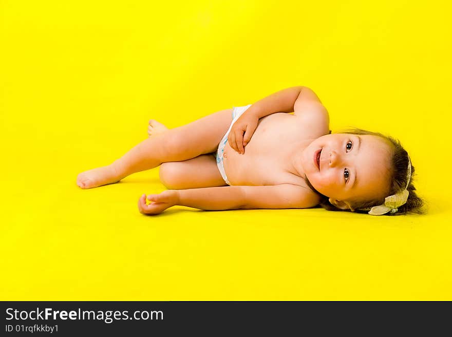 Little girl on the floor over yellow