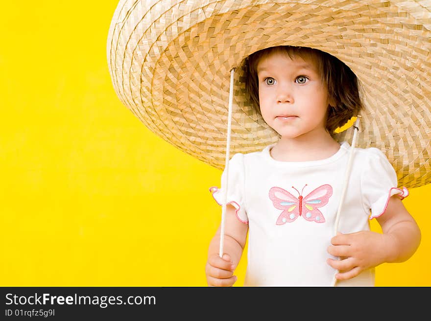 Little baby with big hat, Isolated on yellow