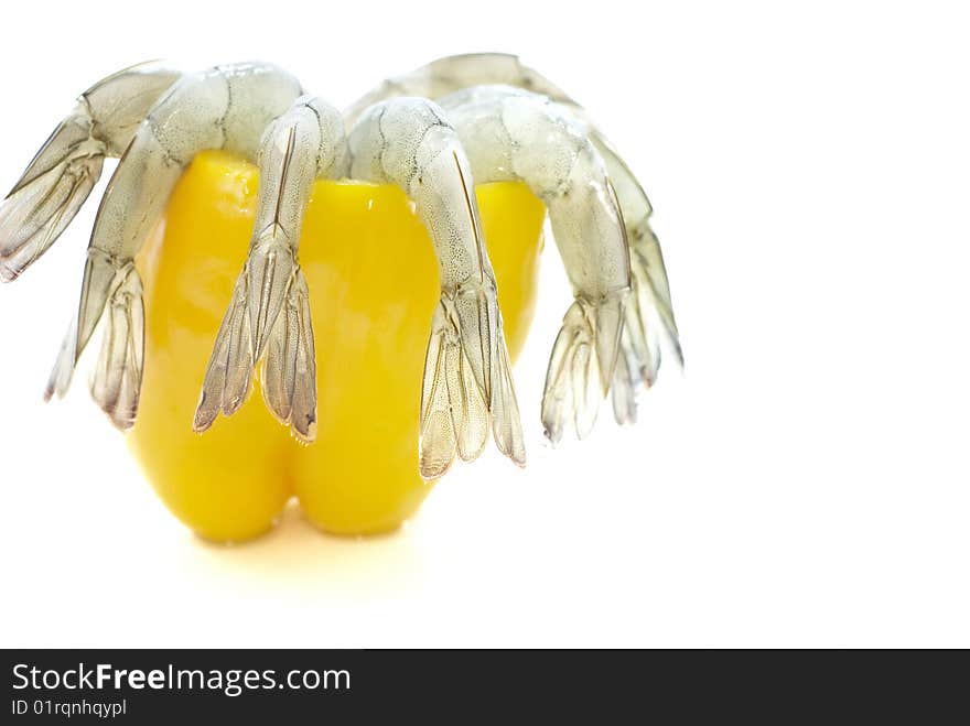 shell off vannamei prawns in emptied yellow pepper isolated on white background taken from side