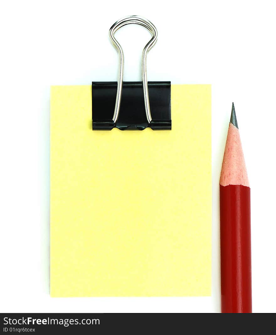 Red pencil, black clipper, and yellow notepad isolated on white background