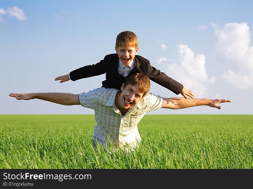 Photo of happy man with his son on back stretching their hands. Photo of happy man with his son on back stretching their hands